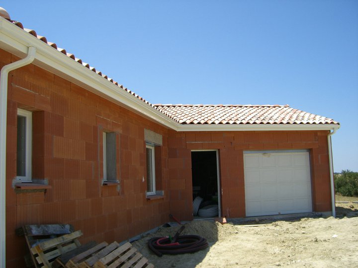 Maison en briques avec garage, gouttières en place
